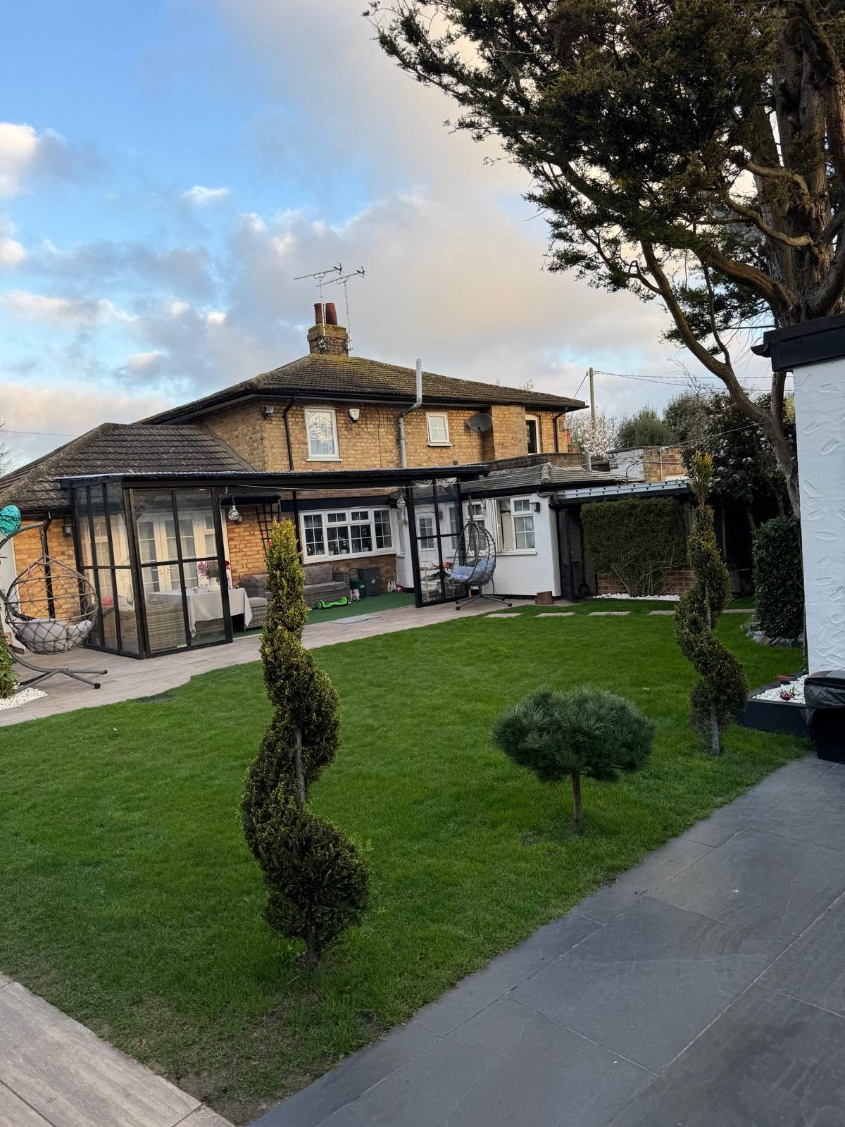 Glazed garden room with new lawn, paving and spiral topiary