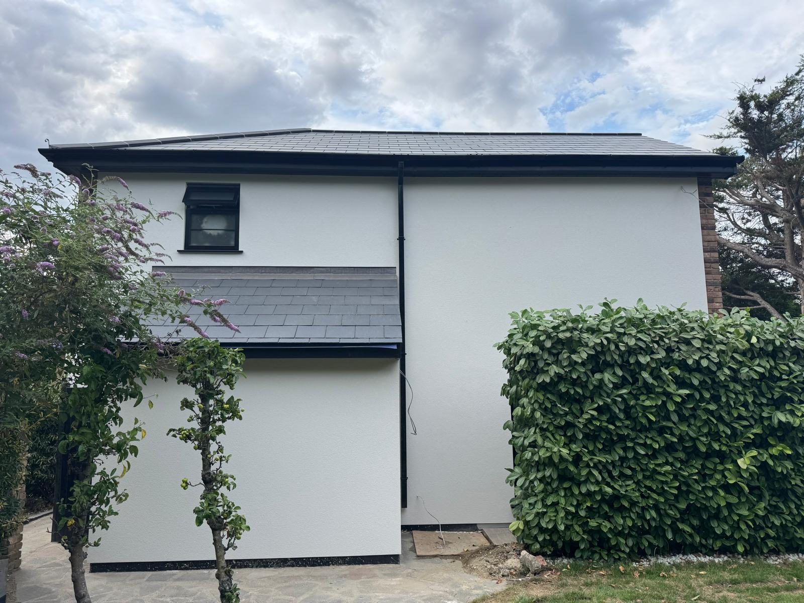 Two-storey elevation with a smooth white render finish and slate roof
