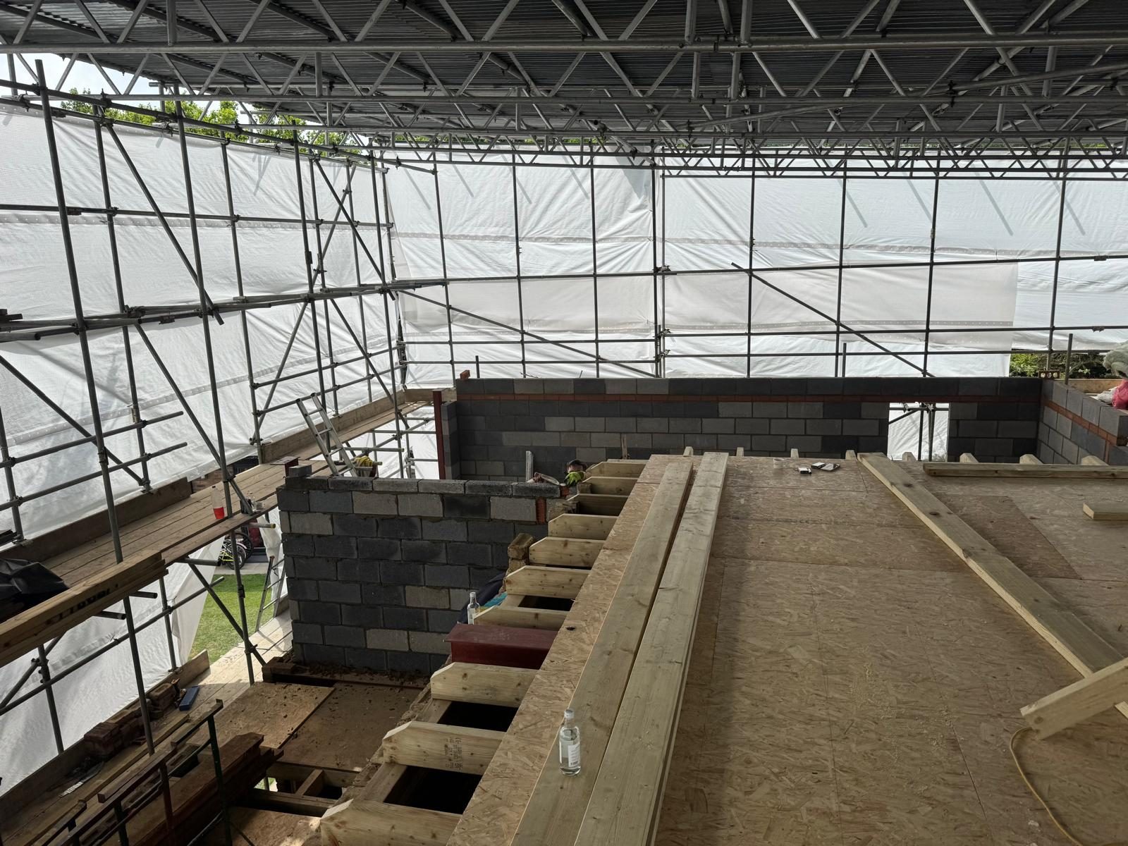 House taken back to its structure under a full scaffold and temporary roof, with new blockwork and floor joists