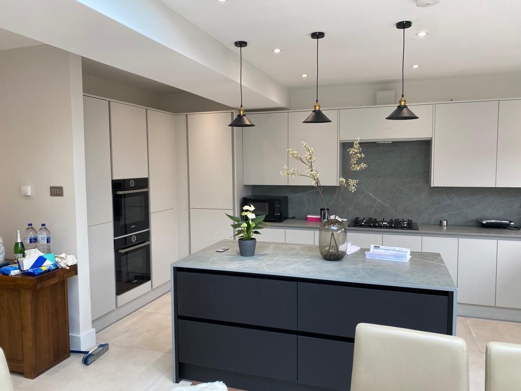 Handleless kitchen with dark island fitted by VAA Construction