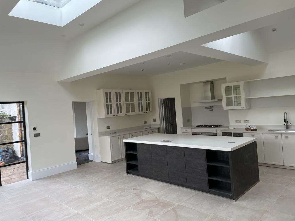 Open-plan kitchen with a dark island after refurbishment